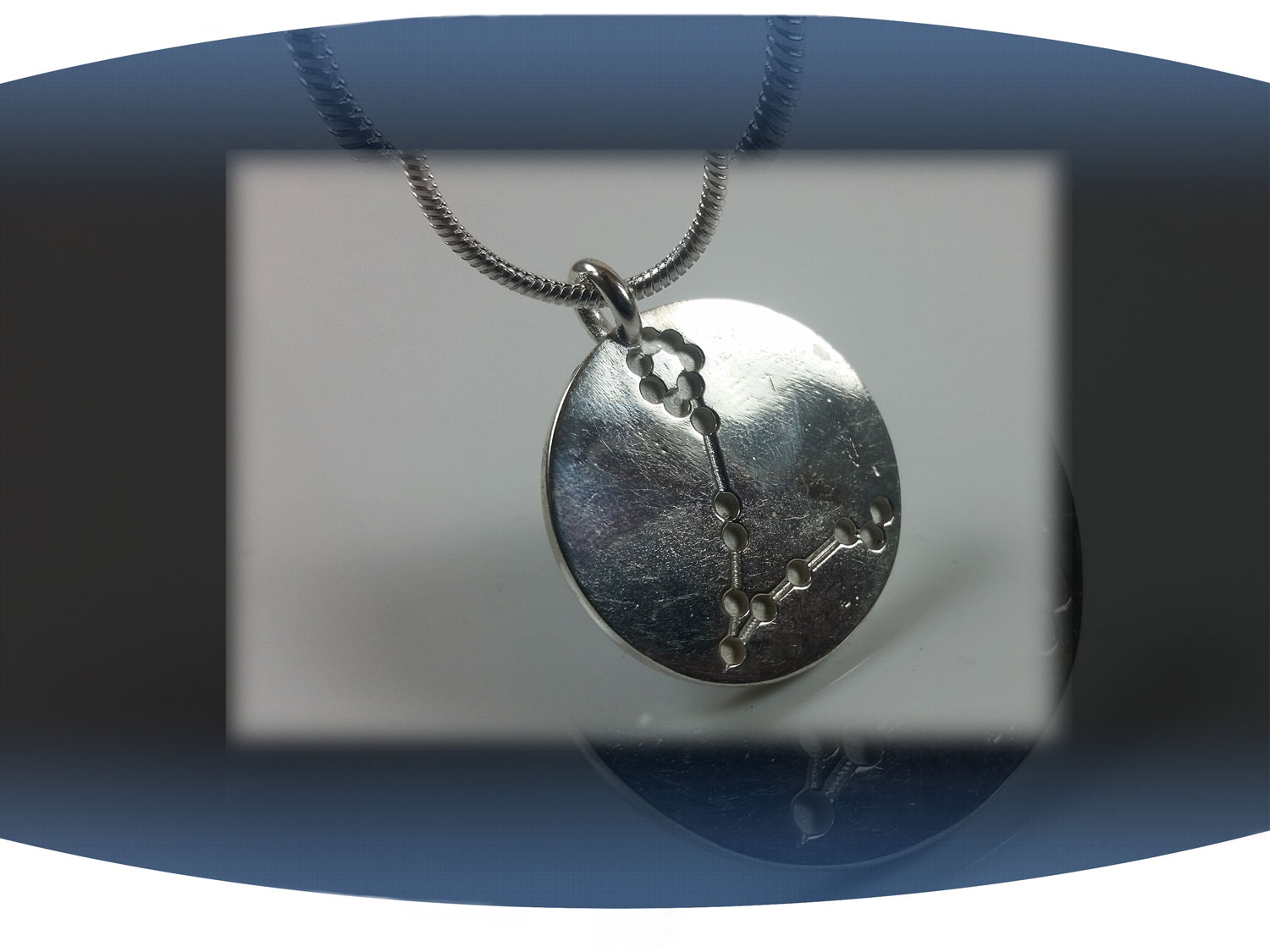 Close up of back of pisces zodiac pendant showing aquarius star constellation