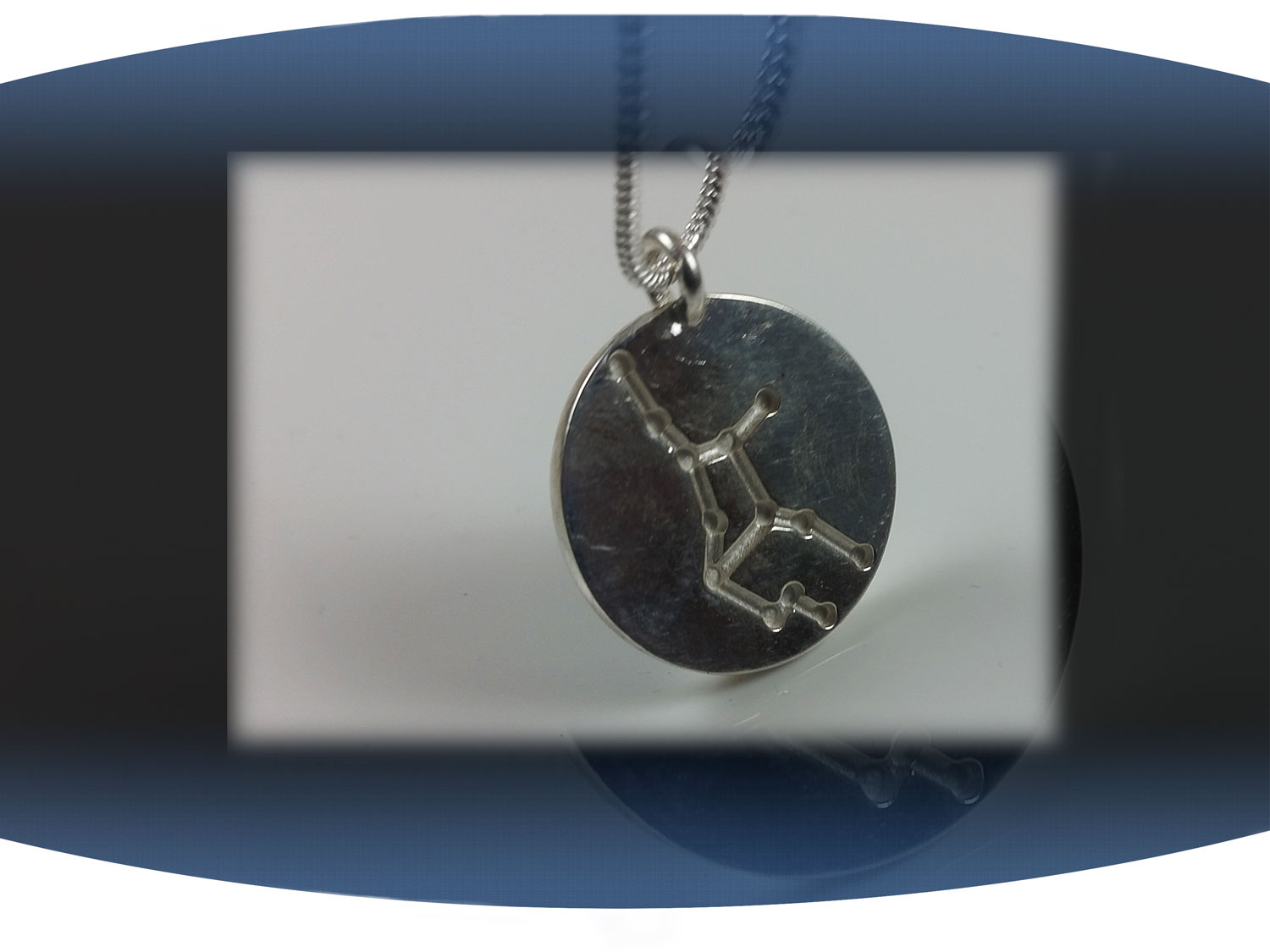 Close up of back of a virgo zodiac pendant showing aquarius star constellation